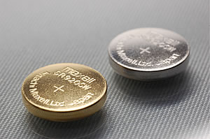 金コーティングボタン電池（左）と従来のニッケルメッキボタン電池（右）